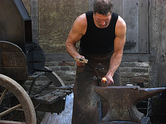 A blacksmith at work at an anvil